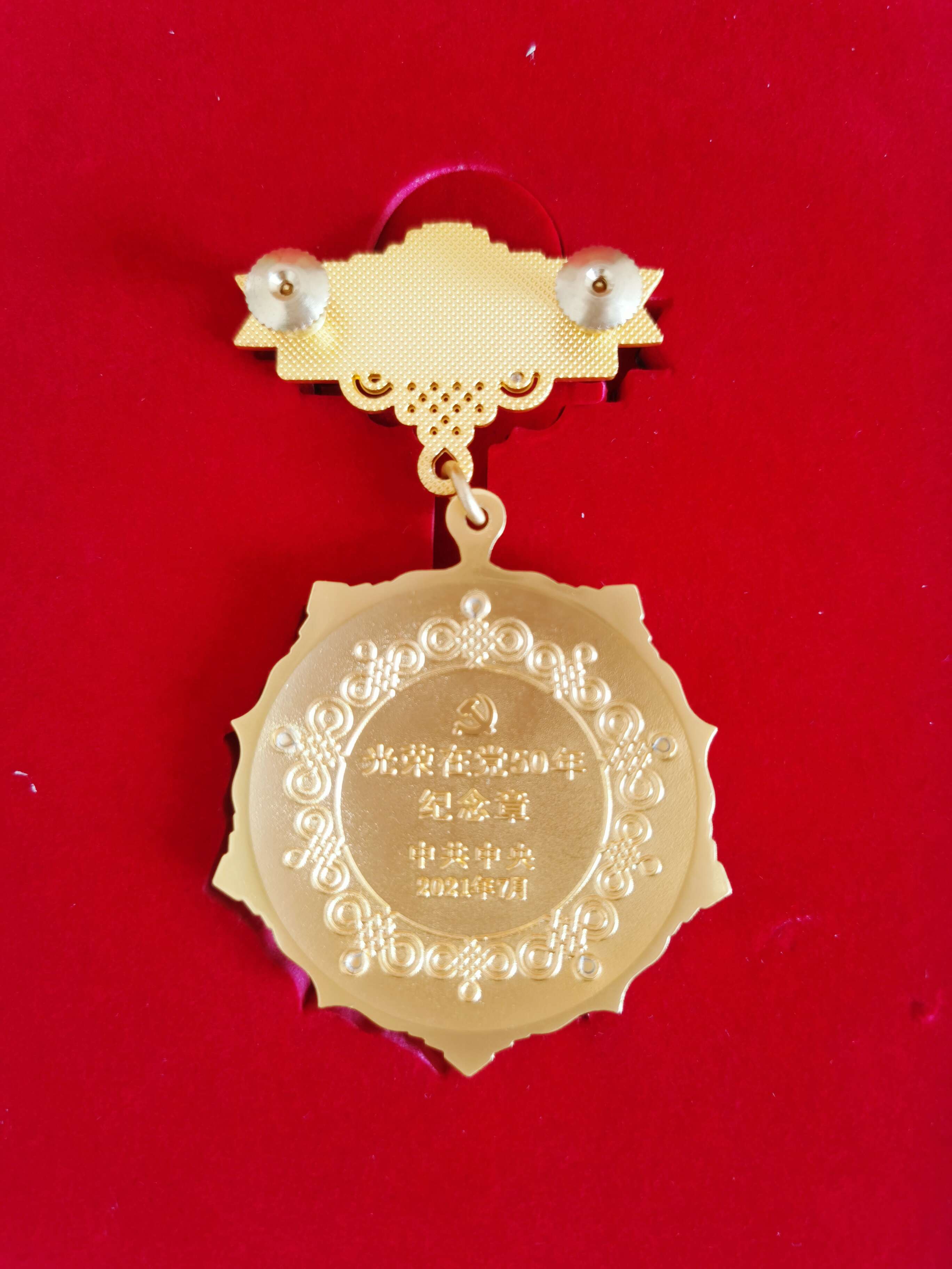 光榮在黨50年紀念獎章背面。  閆慧/攝